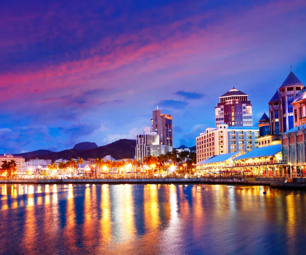 Le Caudan Waterfront lit up at night beside Port Louis harbour
