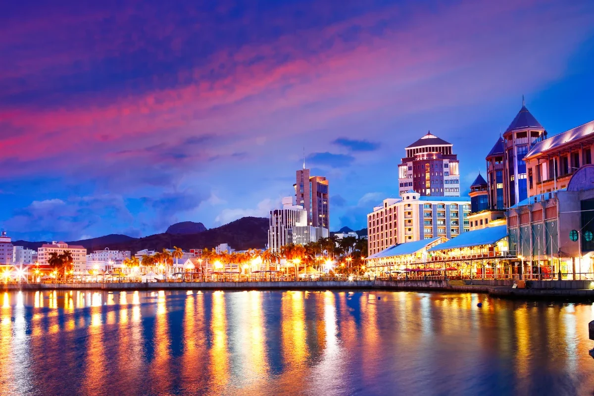 Le Caudan Waterfront lit up at night beside Port Louis harbour