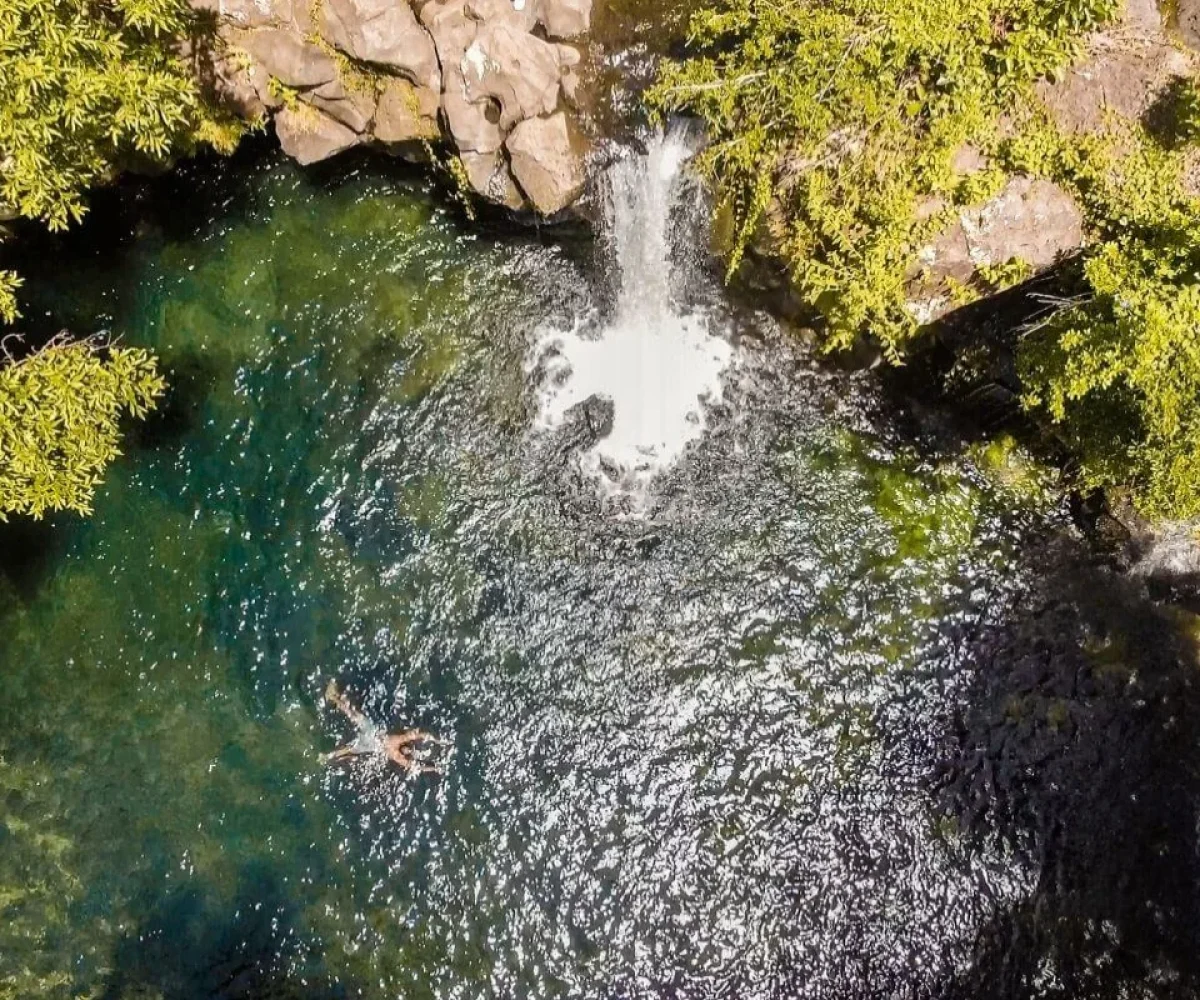 The clear turquoise swimming pool below the Eau Bleue falls