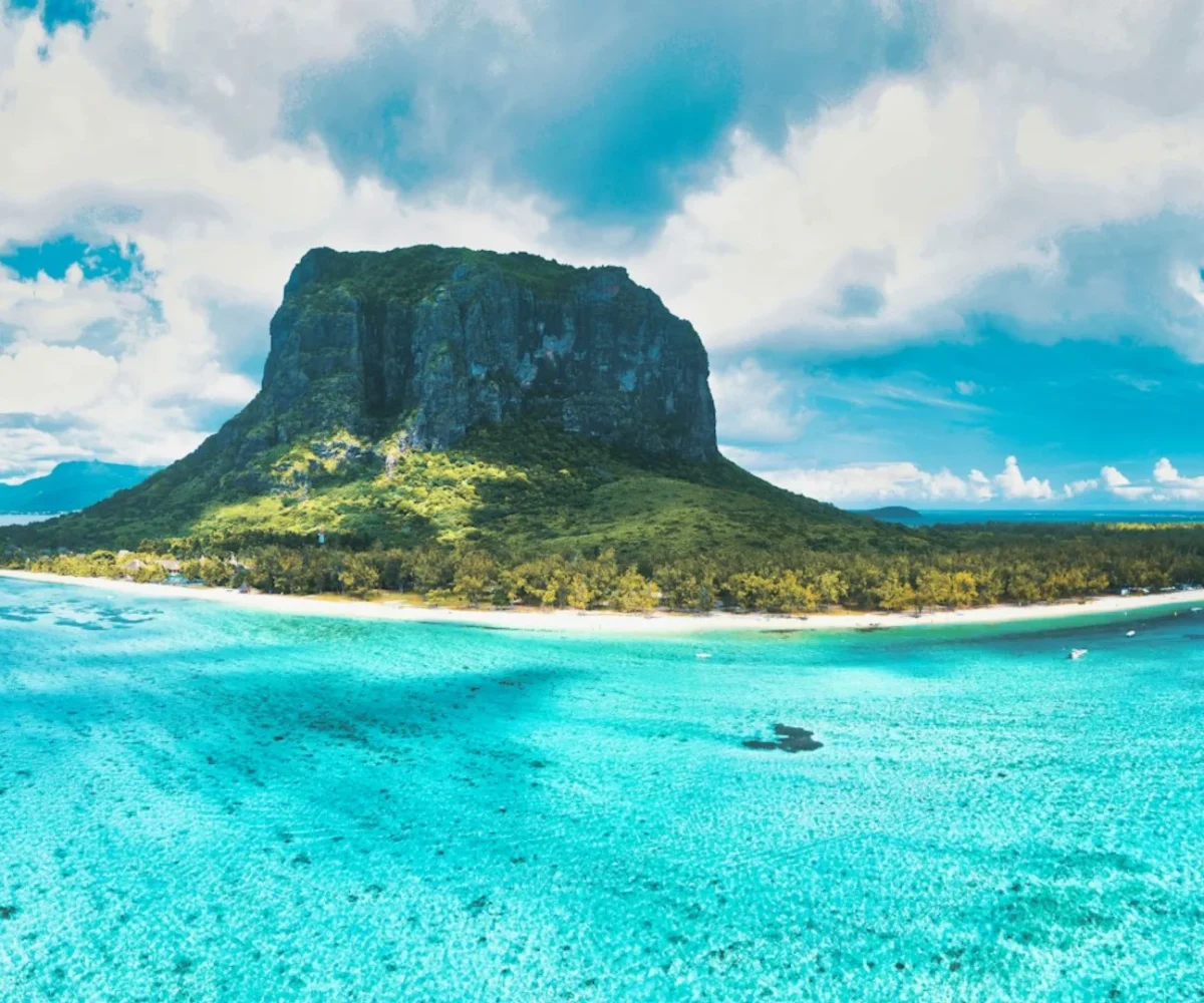 The white sand and calm lagoon of Le Morne beach beneath the mountain