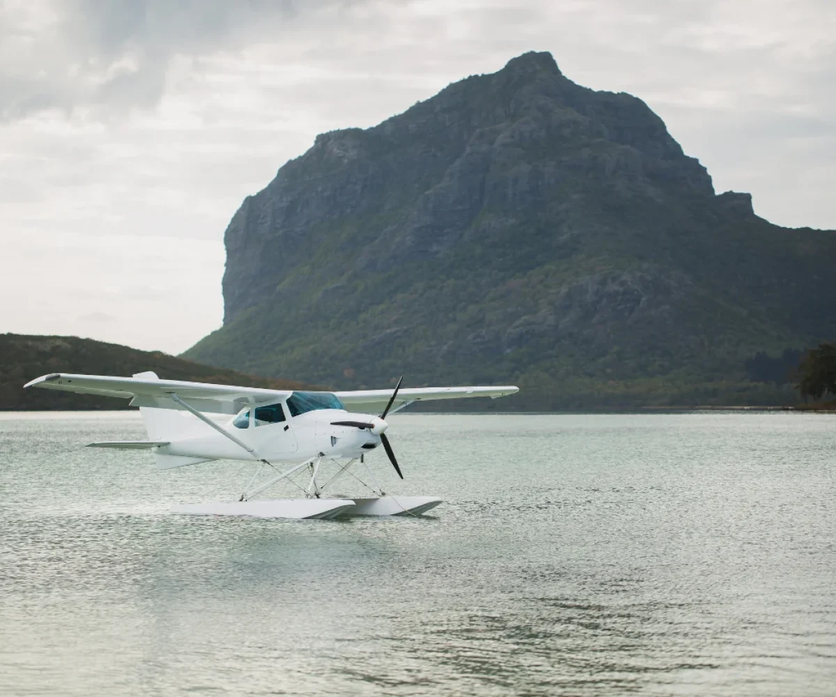 A seaplane flying over the underwater waterfall illusion at Le Morne, Mauritius