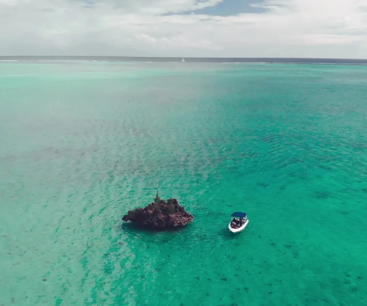 A boat moored alongside Crystal Rock in the shallow lagoon near Le Morne
